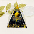 Decorative pyramid with tree of life and moon design on a white background