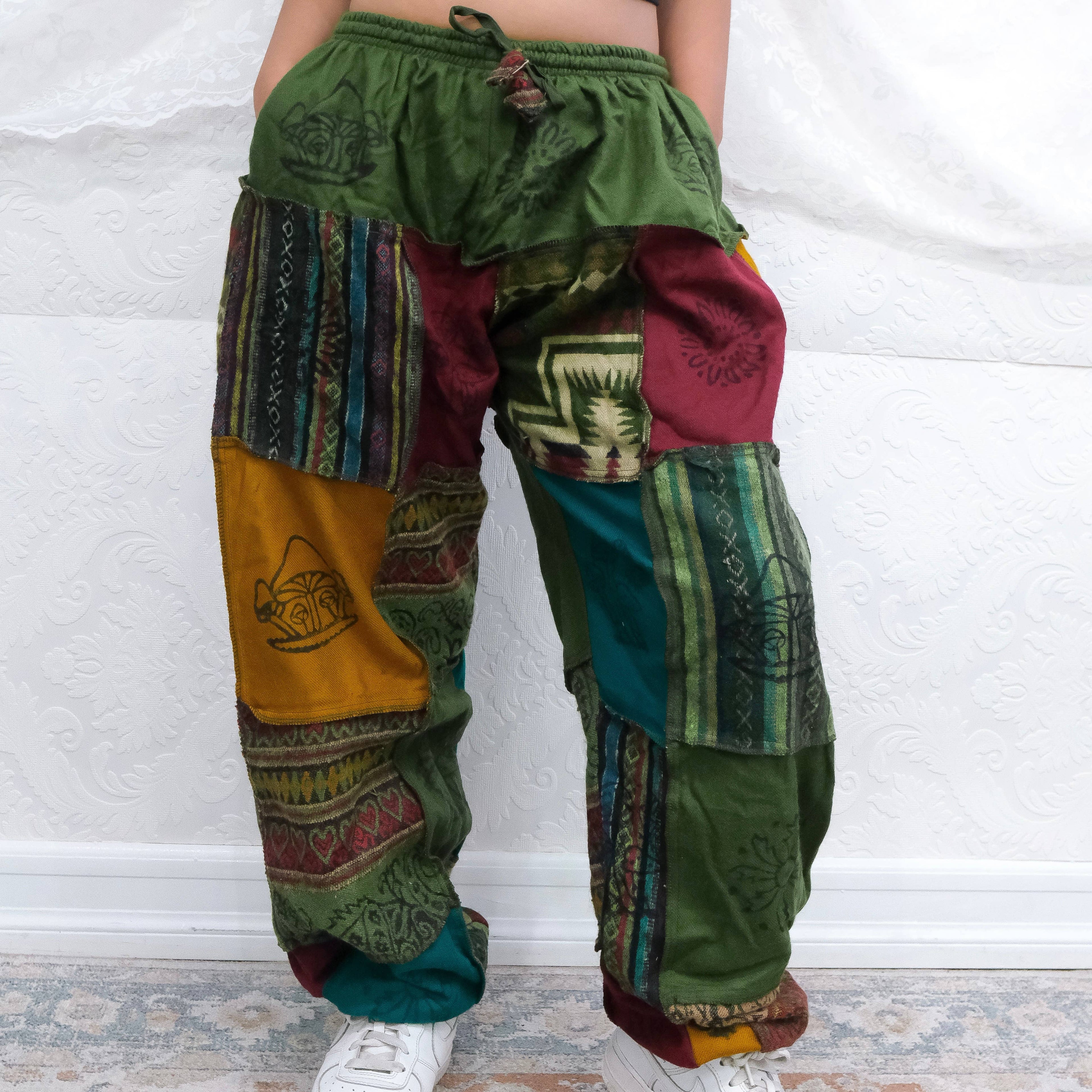 Colorful patchwork pants with intricate patterns on a white background