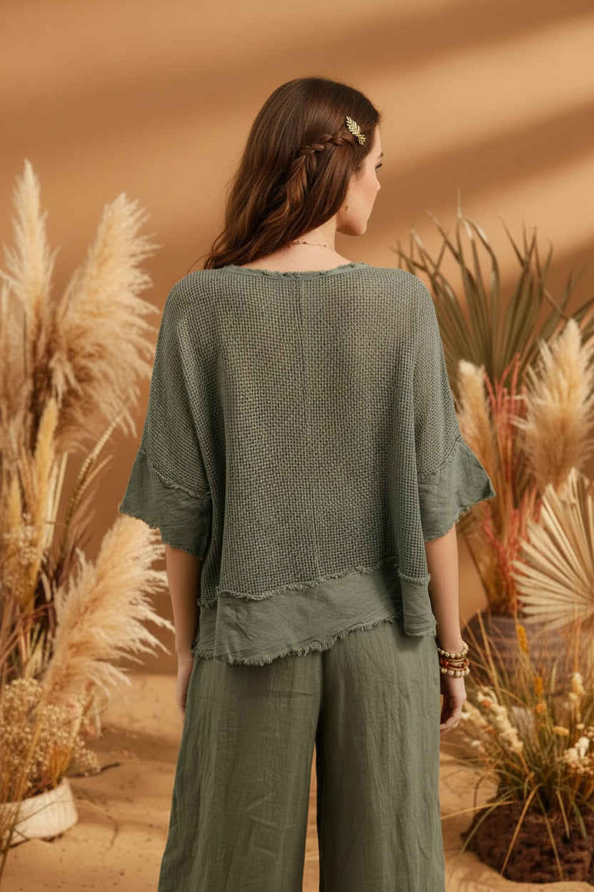 Woman wearing a green textured top and pants against a plain background