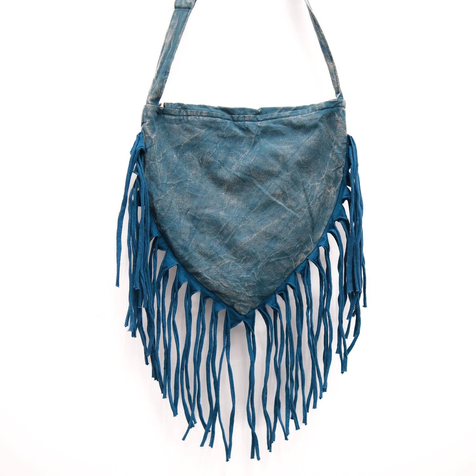 Blue suede handbag with fringe details on a white background