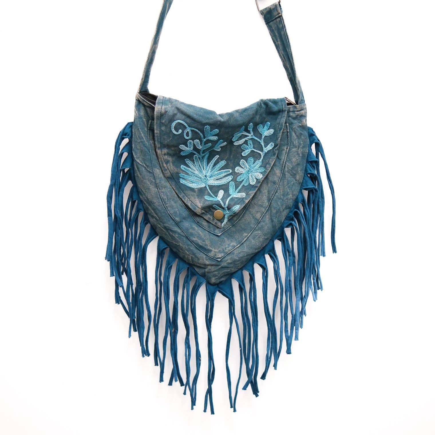 Denim handbag with floral embroidery and fringes on a white background