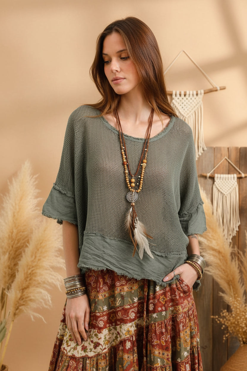 Woman wearing a green textured top and pants against a plain background